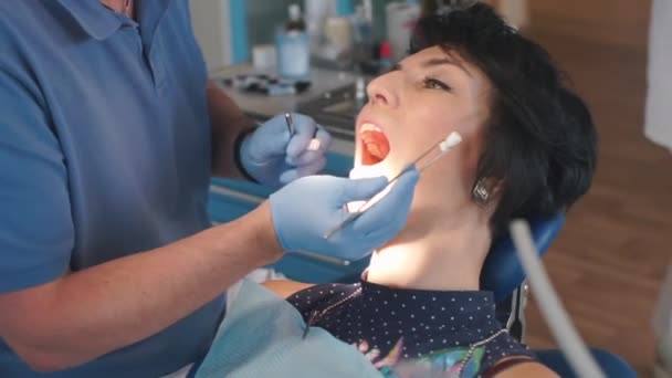 Fogászati eszköz közelsége, fogászati kezelés klinikán — Stock videók