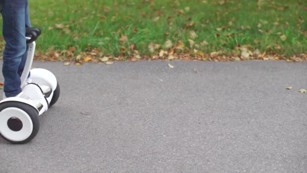 Mithilfe eines Gyroscooters bewegt sich eine Person auf Asphalt vorwärts — Stockvideo