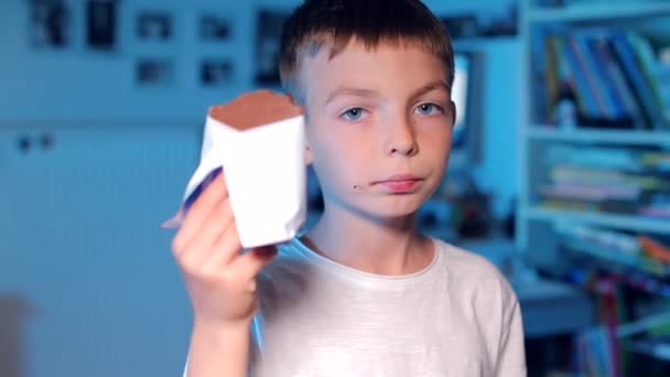Portret van een jongen die chocolade eet — Stockvideo