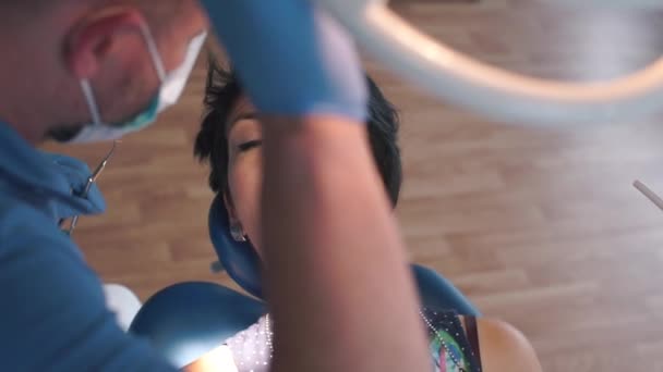 Dentista reparando un diente con una chica en un hospital — Vídeos de Stock