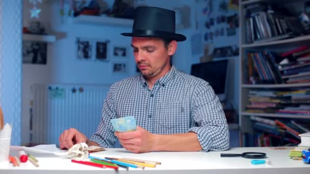 The guy in the hat counts the money at the table, finds one banknote, takes it — Stock Video