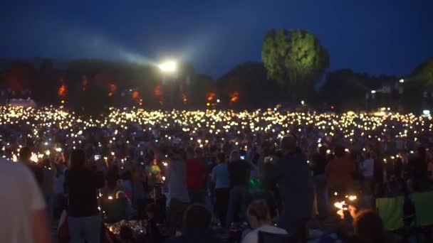 En hel del människor med brinnande tomtebloss står på utomhus — Stockvideo