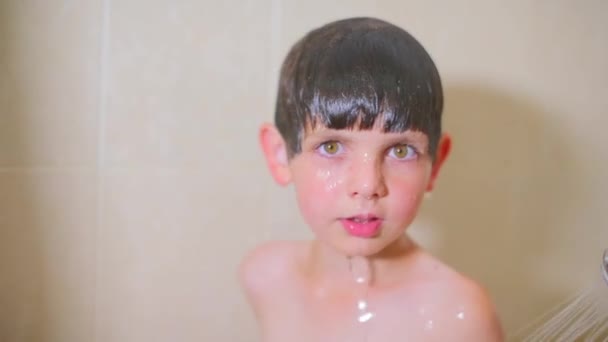 El niño está jugando con un chorro de agua — Vídeos de Stock