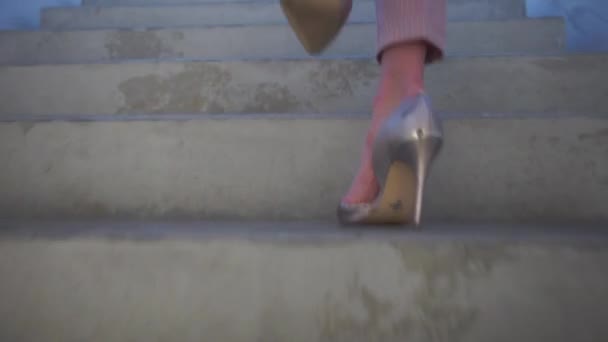 Flickan i klackar går uppför trapporna — Stockvideo