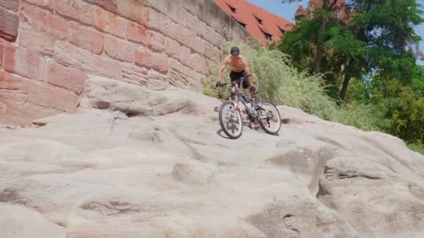 Fietser glijdt van de berg aan de voet van de vesting Neurenberg — Stockvideo