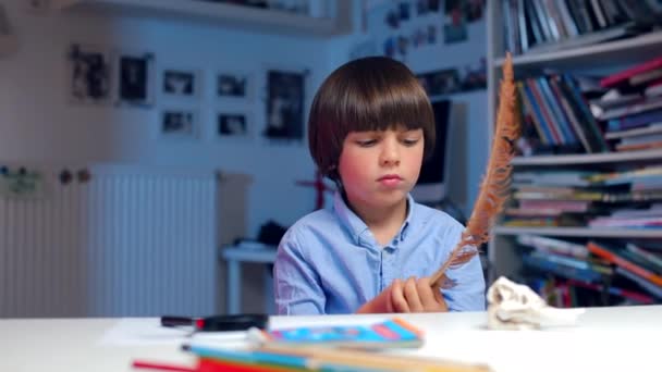 Dziecko bawi się ptasim piórem siedzącym przy stole w przedszkolu — Wideo stockowe