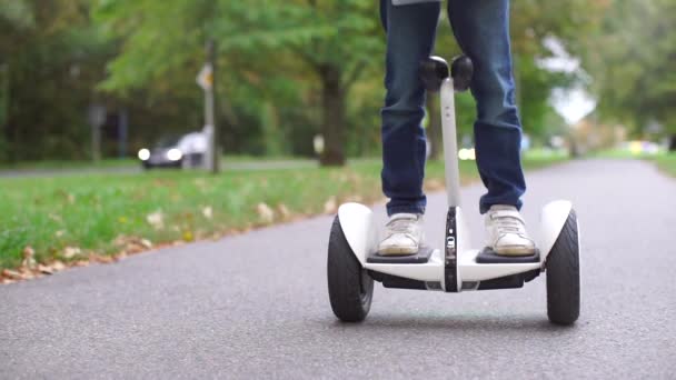 Demostrando el uso de un segway en una carretera asfaltada — Vídeo de stock