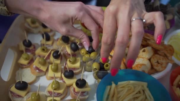 Mesa en la que se encuentra la comida Las niñas toman la comida con los dedos el buffet de la fiesta — Vídeos de Stock