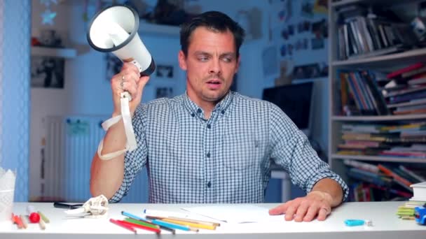 Aggressive politician at the table shouts into a megaphone — Stock Video