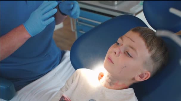 Стоматолог заканчивает осмотр ребенка — стоковое видео