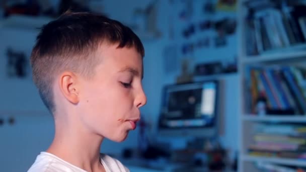 Ένας έφηβος δαγκώνει τα δόντια του με σοκολάτα σε μικρά κομμάτια — Αρχείο Βίντεο