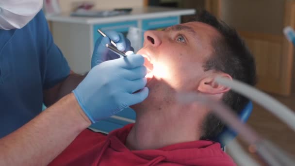 Dentista sta riparando un ragazzo dente in un maglione rosso — Video Stock