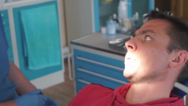 Preparar um paciente para cirurgia dentária em uma clínica odontológica — Vídeo de Stock
