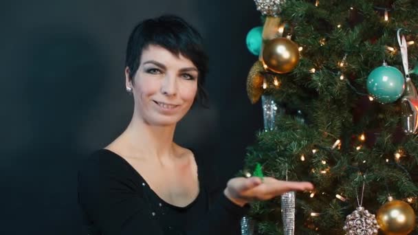 Eine Frau hält ein kleines Weihnachtsbaumspielzeug in der Hand. — Stockvideo