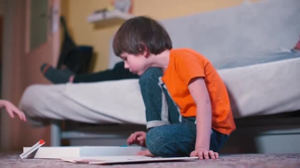 Kinder spielen im Kindergarten ein Brettspiel auf dem Fußboden. — Stockvideo