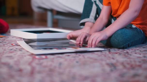 Närbild av händerna på ett barn som spelar ett brädspel på golvet. — Stockvideo