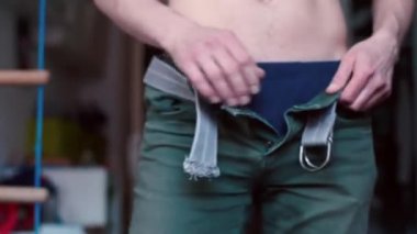 Bir adam işe gitmeden önce yeşil pantolon giyer..
