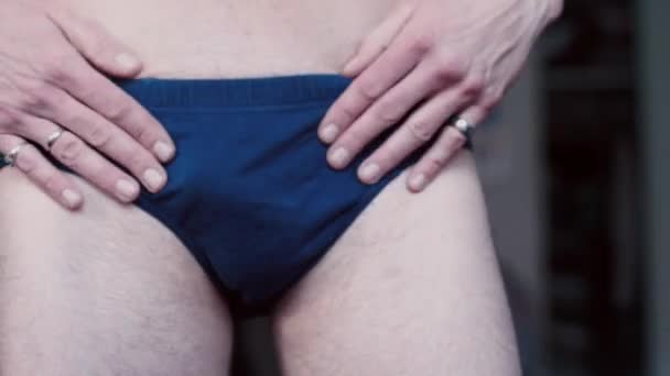 Egy férfi felöltözik és kiegyenesíti az alsógatyáját a testén.. — Stock videók