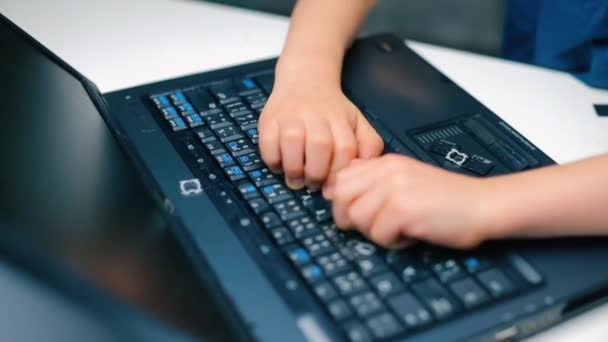 Arg pojke bryter laptop tangentbord med händerna. — Stockvideo