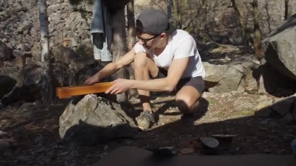 O cara coloca uma mesa na pedra — Vídeo de Stock