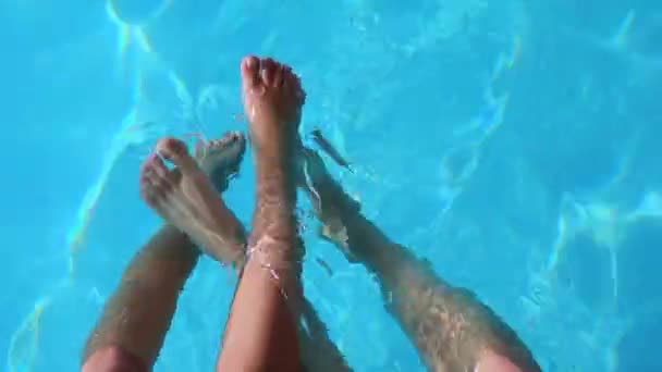 Pies de un par de personas jugando en el agua — Vídeo de stock