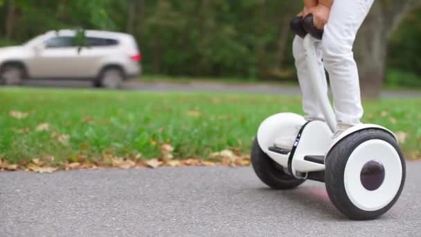 Een tiener staat op een segway en maakt vooruit en achteruit bewegingen — Stockvideo