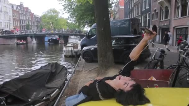 Девушка делает селфи на капоте машины — стоковое видео
