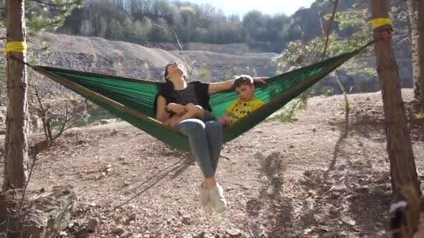 Woman lying in a hammock with a boy — 비디오