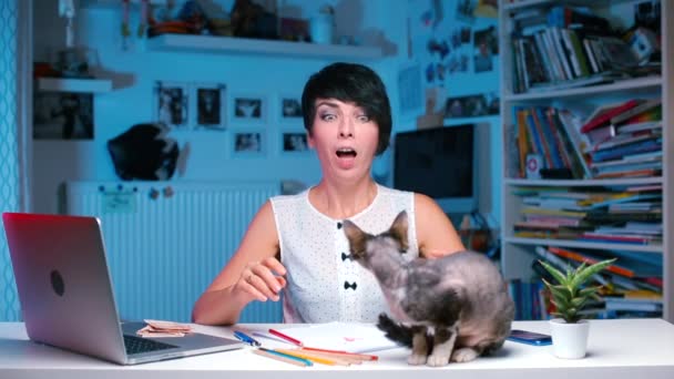 Дівчина з алергією, сидячи за столом, чхає з хутра кота . — стокове відео