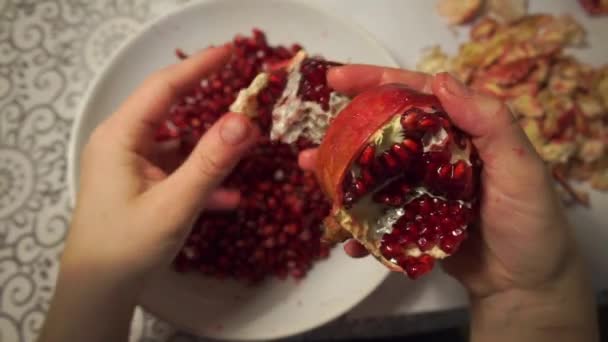 les mains nettoient la grenade dans une assiette 