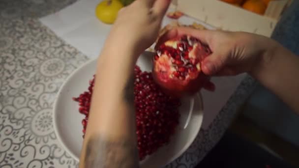 Limpiar la granada en un plato — Vídeo de stock