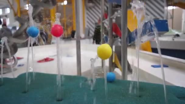 Tre flerfärgade bollar ligga på jetstrålar av vatten — Stockvideo