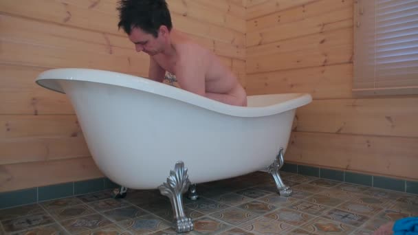 Un hombre se prepara para tomar un baño. . — Vídeos de Stock