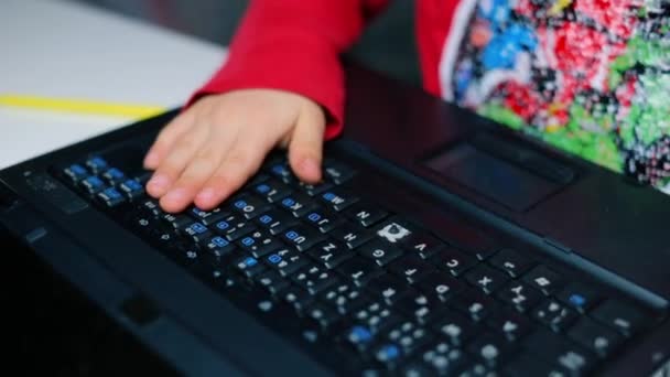 Ребенок бьет руками по клавиатуре ноутбука . — стоковое видео