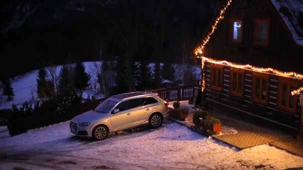 Ένα αυτοκίνητο είναι παρκαρισμένο κοντά σε ένα ξενοδοχείο στα βουνά.. — Αρχείο Βίντεο