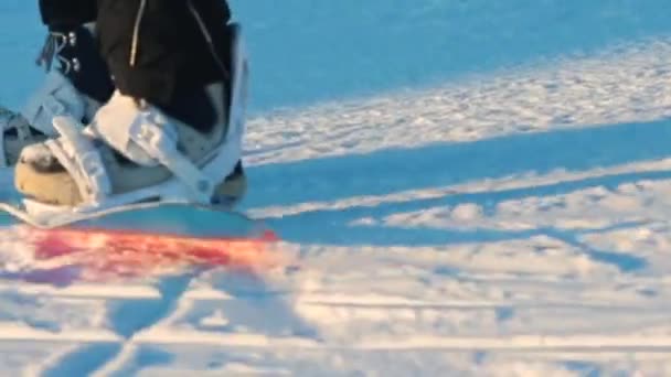 Snowboardista nohy na snowboardu v pohybu na sněhu na hoře. — Stock video