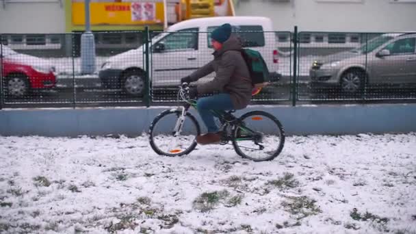 Hij fietst in de sneeuw in de tuin.. — Stockvideo