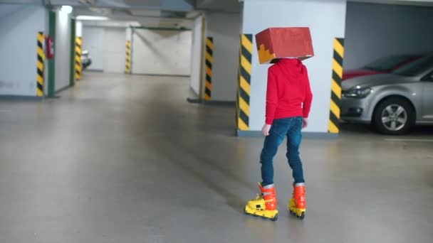 Chłopiec w czerwonych ubraniach w masce na głowie jeździ na rolkach.. — Wideo stockowe