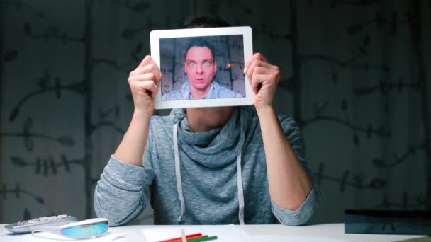 La cara de un hombre sorprendido en la pantalla de la tableta . — Vídeos de Stock