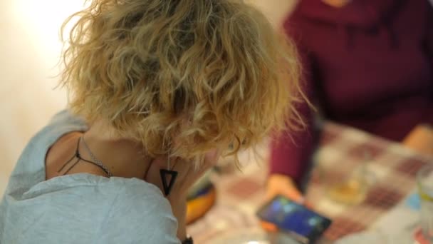 Un primer plano del pelo de la cabeza de una chica sentada en una mesa . — Vídeos de Stock