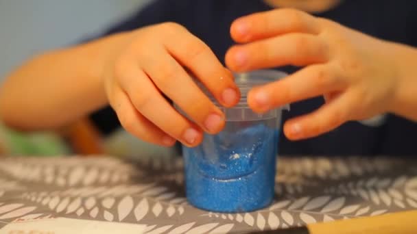 Detailní záběr malé plechovky s modrou barvou na stole. — Stock video