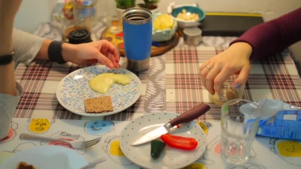 Primo piano di un tavolo con cibo. Sul tavolo ci sono le mani di due ragazze . — Video Stock