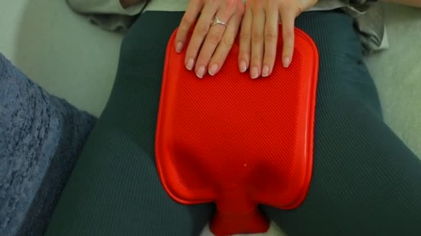Gros plan d'un coussin chauffant rouge sur l'estomac d'une fille . — Video