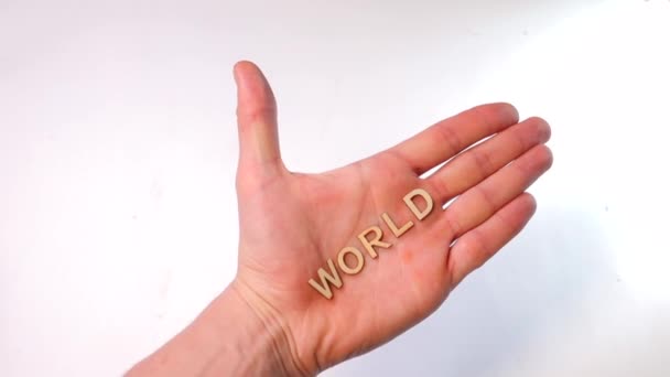 Närbild av en hand. På handen ligger ordet värld. — Stockvideo