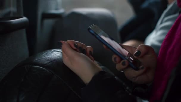 Een meisje fotografeert spijkers op een smartphone terwijl ze in een passagiersbus zit. — Stockvideo