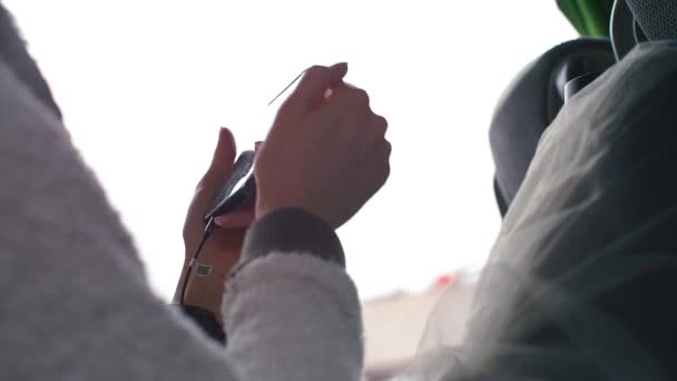 Девушка использует мобильный телефон в своих руках . — стоковое видео