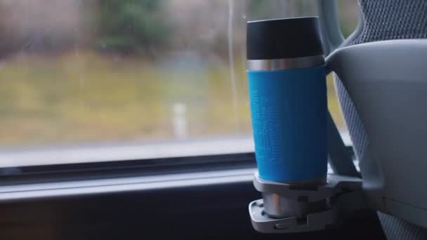 Primo piano di una tazza termica di una sedia di autobus turistico in piedi in un portabicchieri . — Video Stock