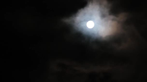 Gros plan du mouvement des nuages sur le fond de la lune la nuit .