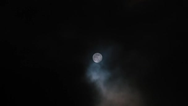 El movimiento de las nubes sobre el telón de fondo de la luna llena en la noche . — Vídeo de stock