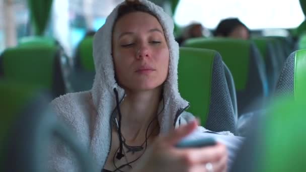 一辆公共汽车上戴着白色头巾的女孩的肖像用的是智能手机. — 图库视频影像